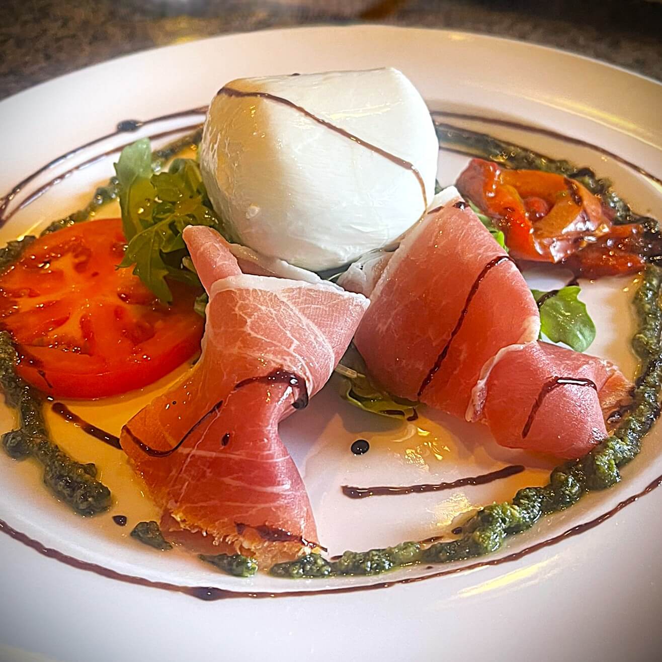 Fresh mozzarella and prosciutto with tomato pesto and balsamic