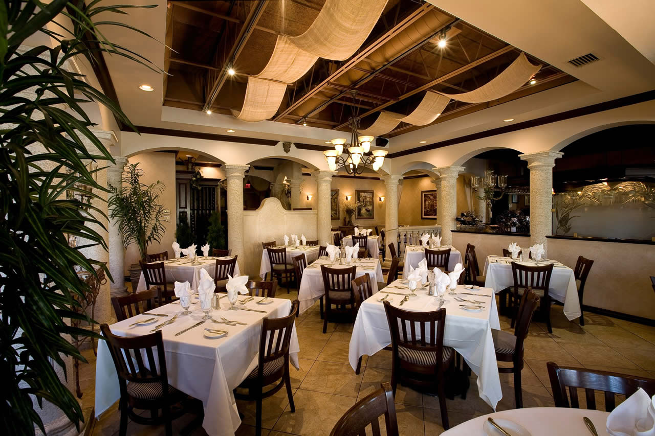 Josephine's main dining room with stone columns, chandelier, and white linen tables